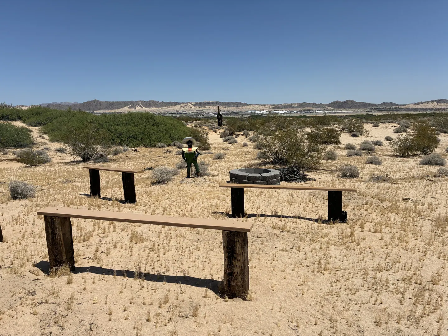 Benches gathered around a fire ring in the open desert