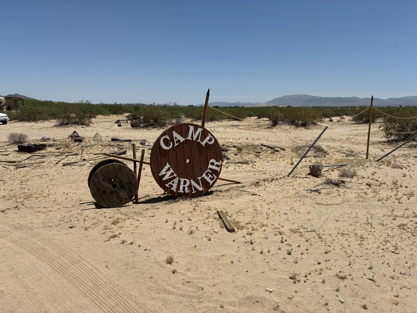 Hand-painted Camp Warner sign on a wooden cable spool