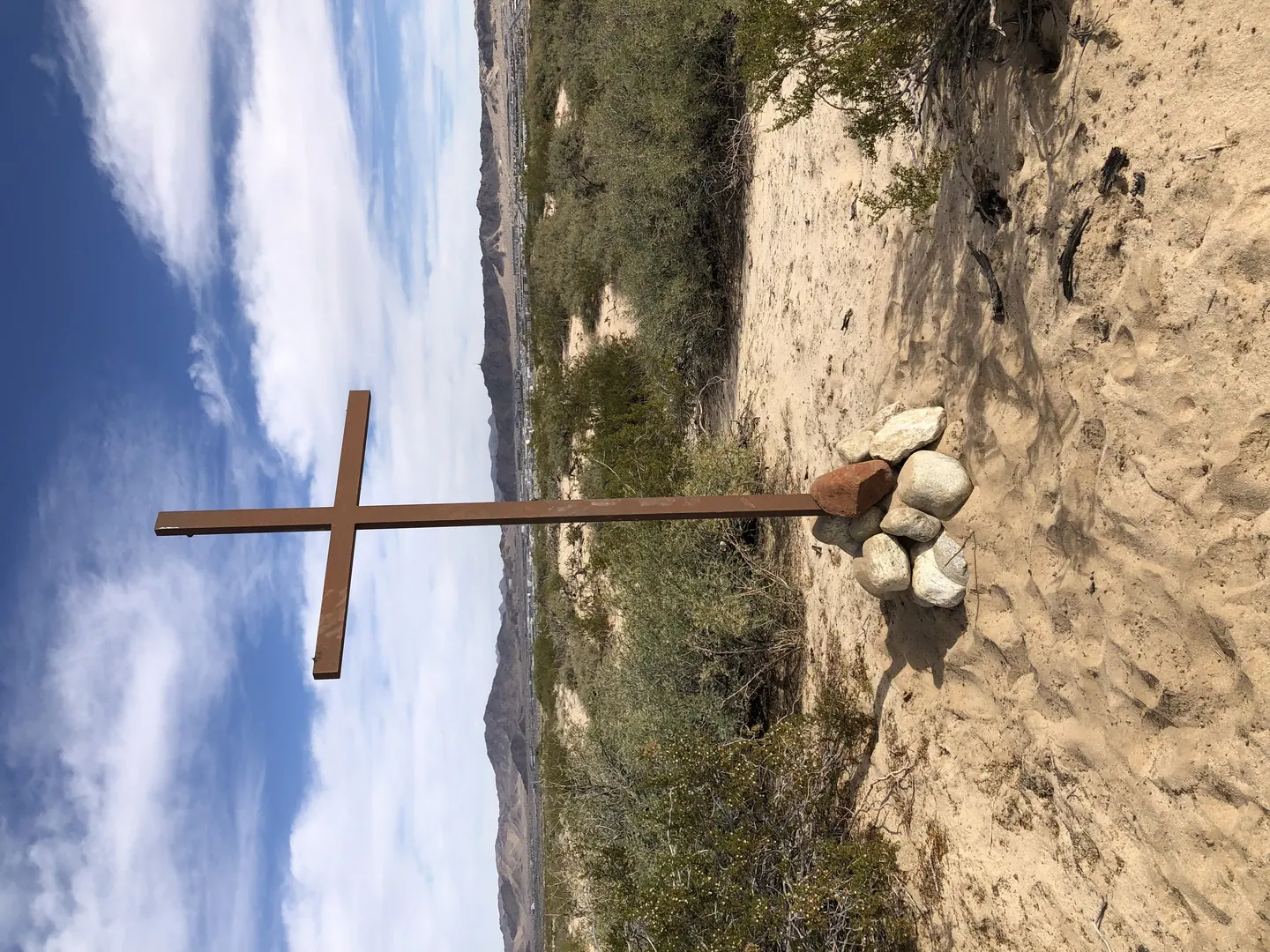 A wooden cross standing in the open desert landscape