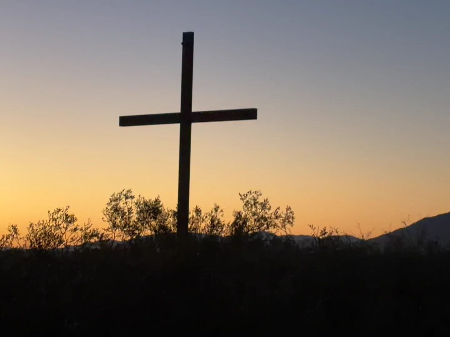 A wooden cross silhouetted against the sunset at Camp Warner